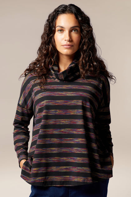 A woman wearing a plush jersey Spacedye Stripe Cowl Neck top.