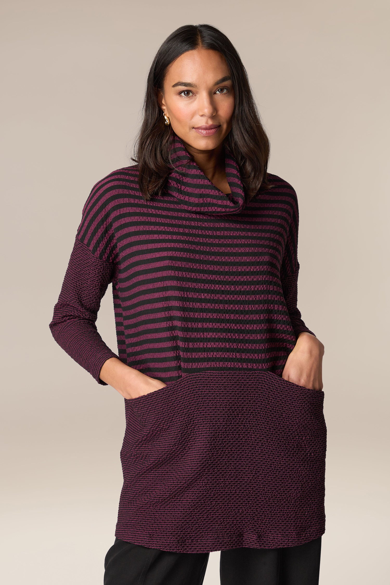 A woman wearing a Crinkle Stripe Cowl Neck Tunic with black and burgundy striped patterns.