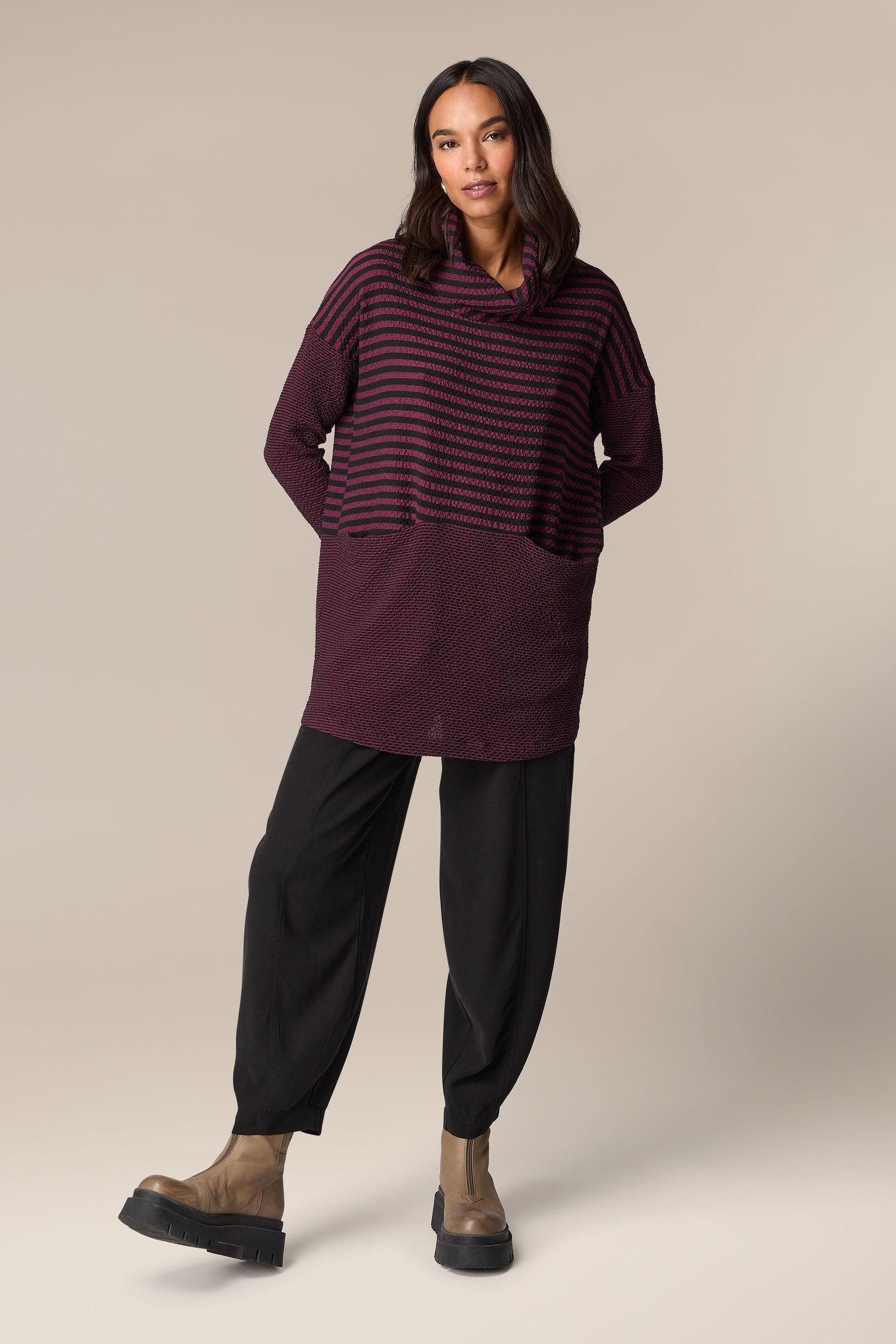 A woman wearing a [Crinkle Stripe Cowl Neck Tunic] with black pants.