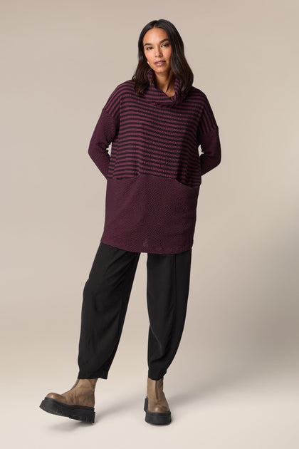 A woman wearing a [Crinkle Stripe Cowl Neck Tunic] with black pants.