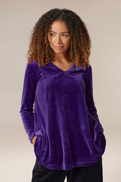 A woman wearing a luxury purple Velvet Jersey Swing Top.