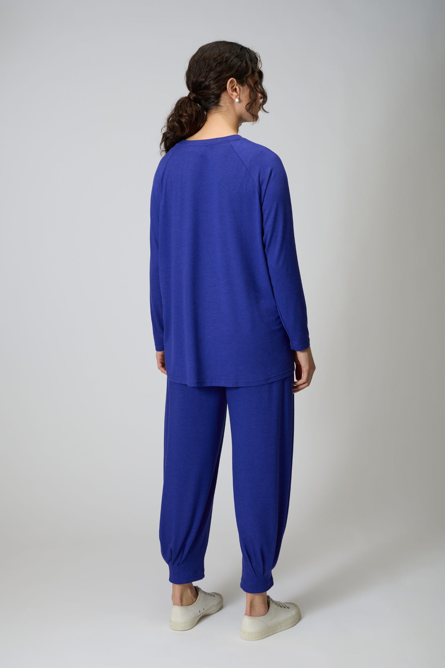 A person stands facing away from the camera, wearing the Soft Viscose Jersey Boxy Top and matching blue pants with white sneakers.