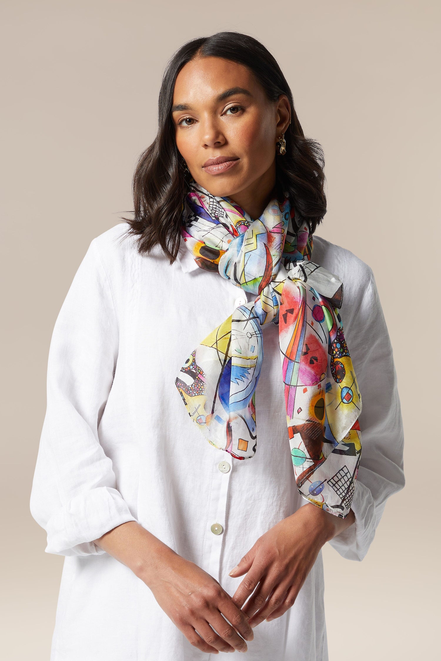 A woman wearing a white silk shirt and a Cubist Silk Scarf.