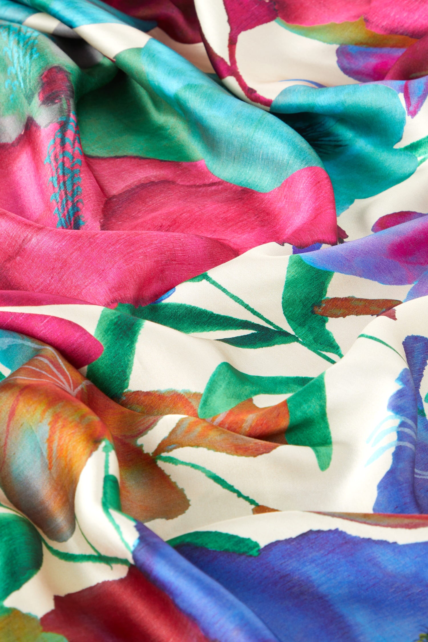 Colorful silk scarves with vibrant watercolor Floral Kaftans, elegantly draped to showcase their texture and design.