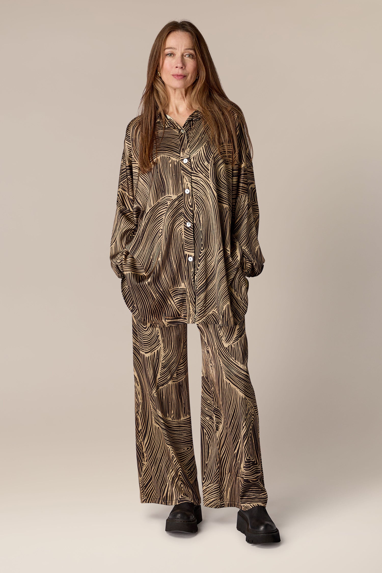A woman wearing Swirl Pant, a contemporary long-sleeved pajama set with artisanal flair.