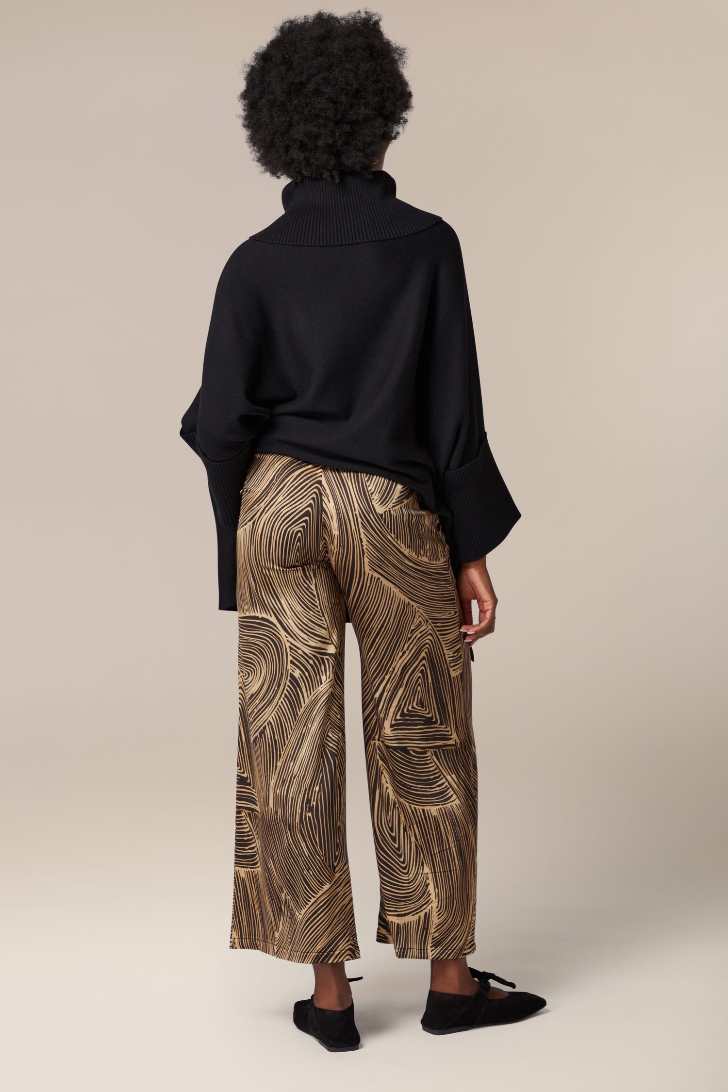 The back view of a woman wearing Swirl Trouser with artisanal flair.