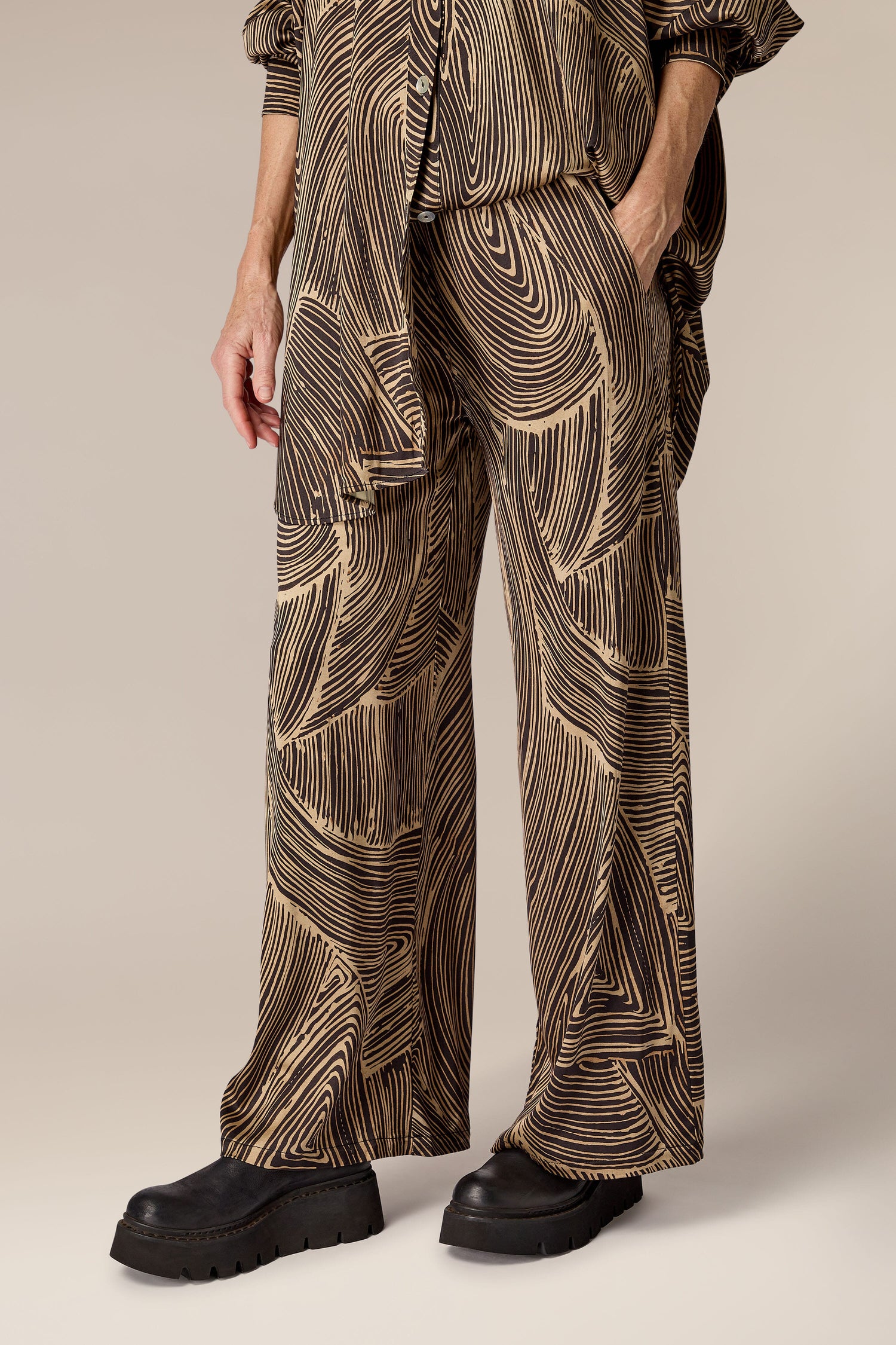 A man wearing a contemporary design patterned shirt and the Swirl Pant.