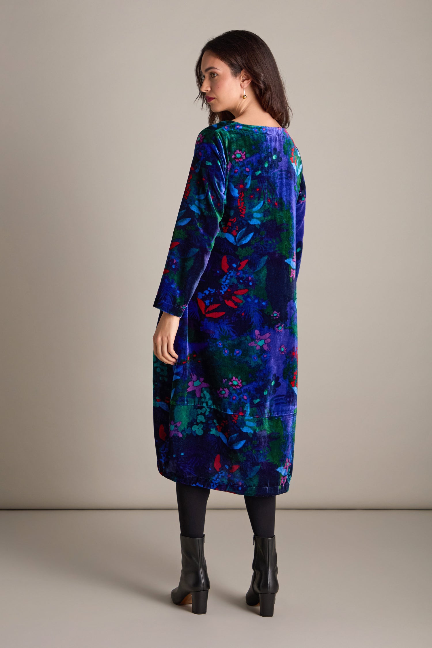 A person stands against a neutral background, wearing the Late Night Flora Velvet Bubble Dress paired with dark tights and black ankle boots, creating an ensemble perfect for evening events.