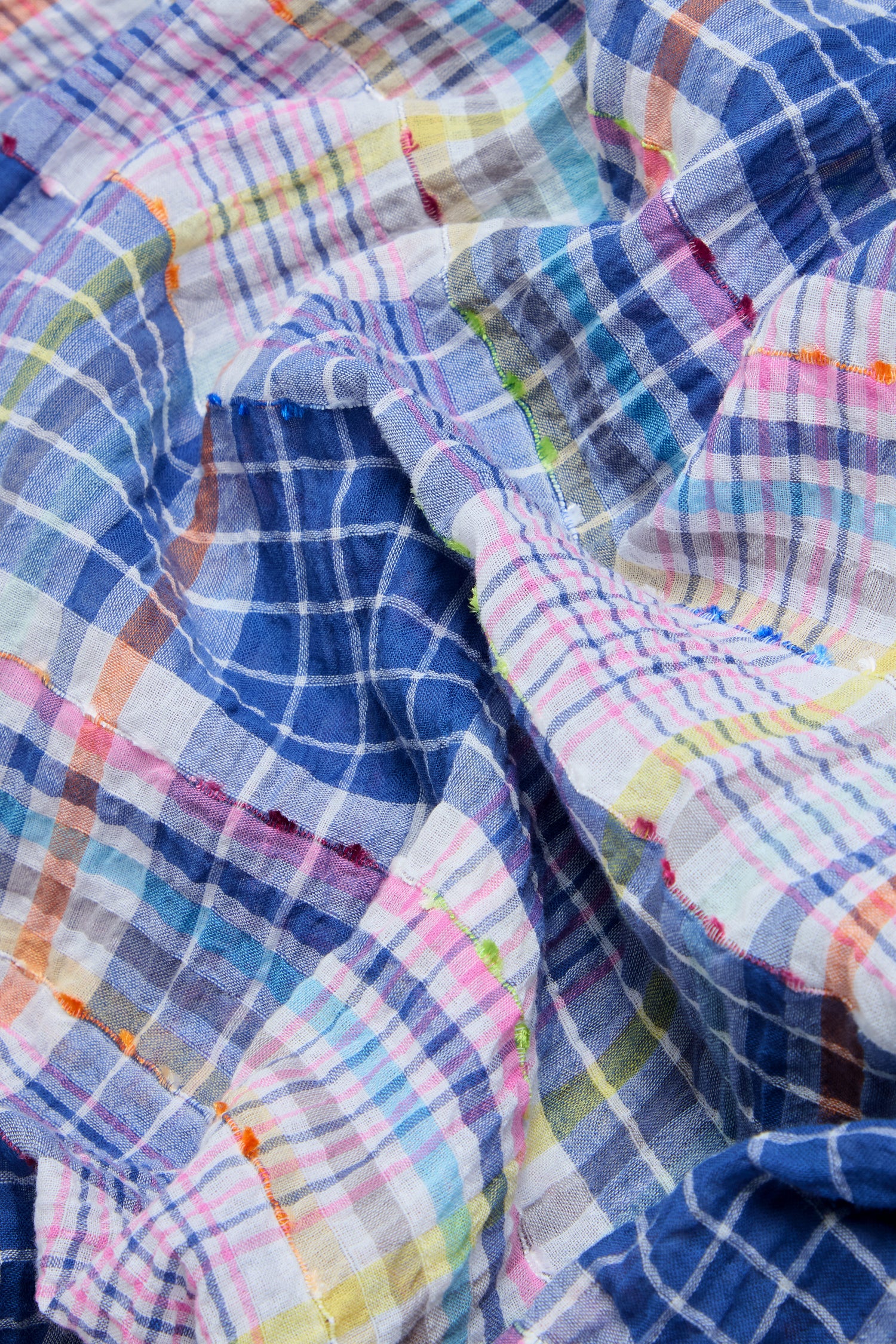Close-up of the Crinkle Check Jacquard Dress’s cotton-rich fabric, showcasing its wrinkled texture and intersecting blue, white, pink, and multicolored plaid lines.