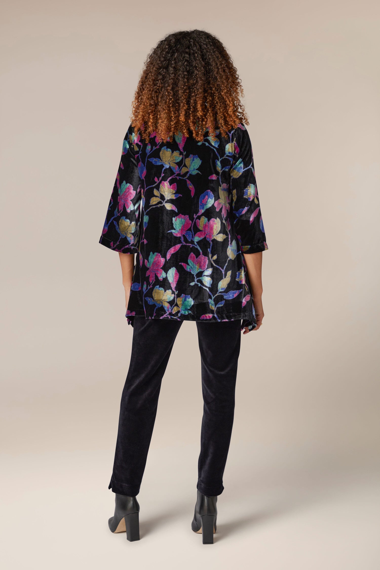 The back view of a woman wearing a Winter Magnolia Velvet Tunic.