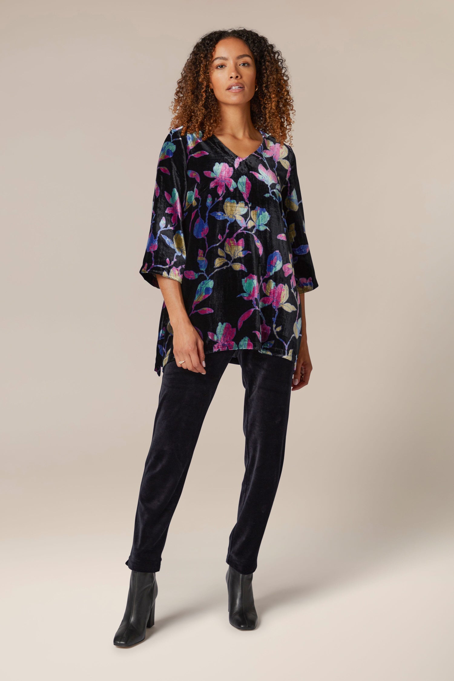 A woman wearing a Winter Magnolia Velvet Tunic and black pants.