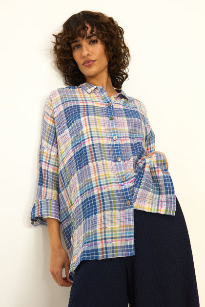 Woman wearing the Crinkle Check Jacquard Shirt, a loose, multicolored cotton-rich top with three-quarter sleeves, paired with dark textured pants, standing against a plain white background.