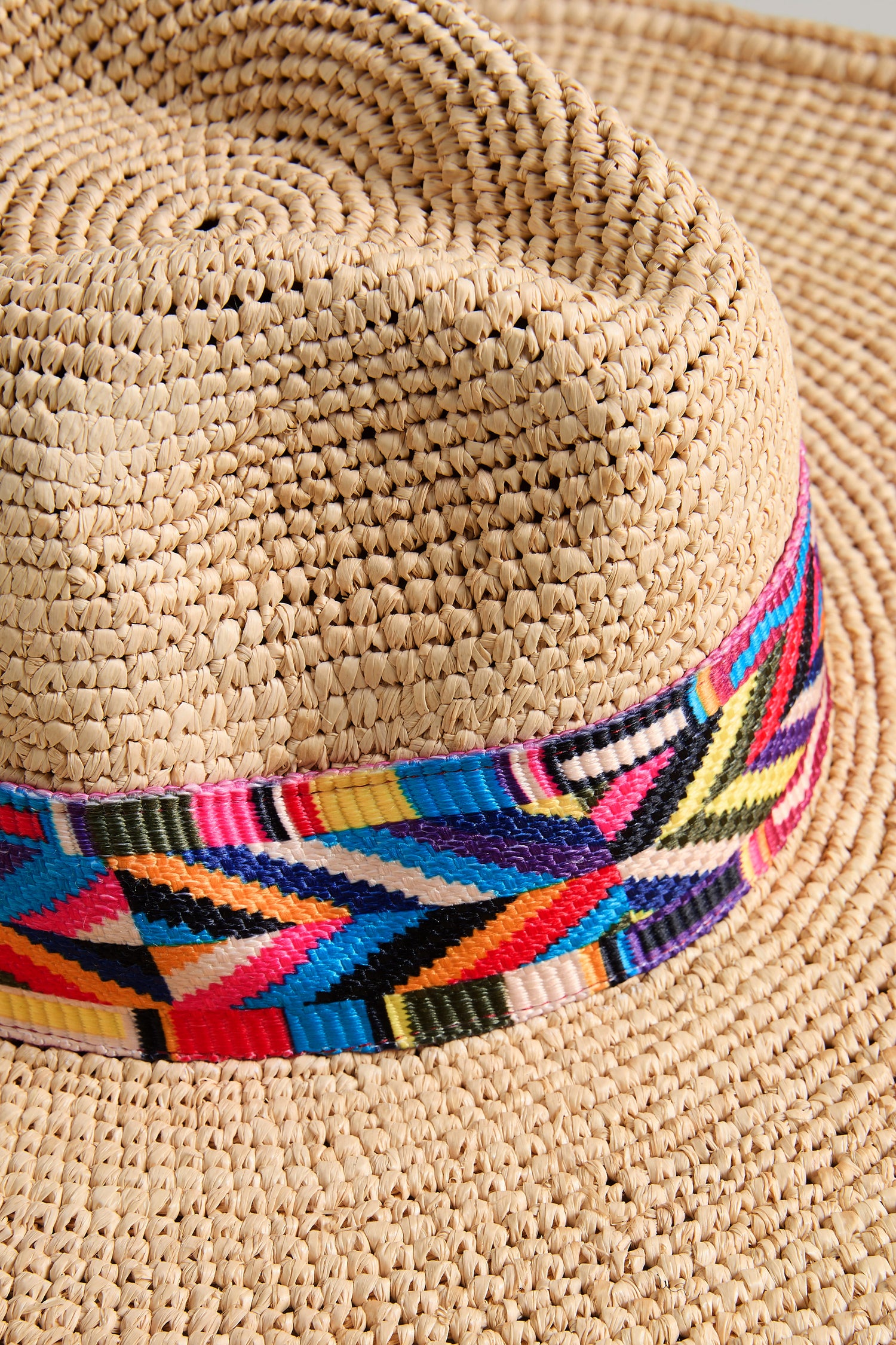 Close-up of the Handwoven Raffia Western Hat, style TON1160B, featuring a colorful geometric patterned band.