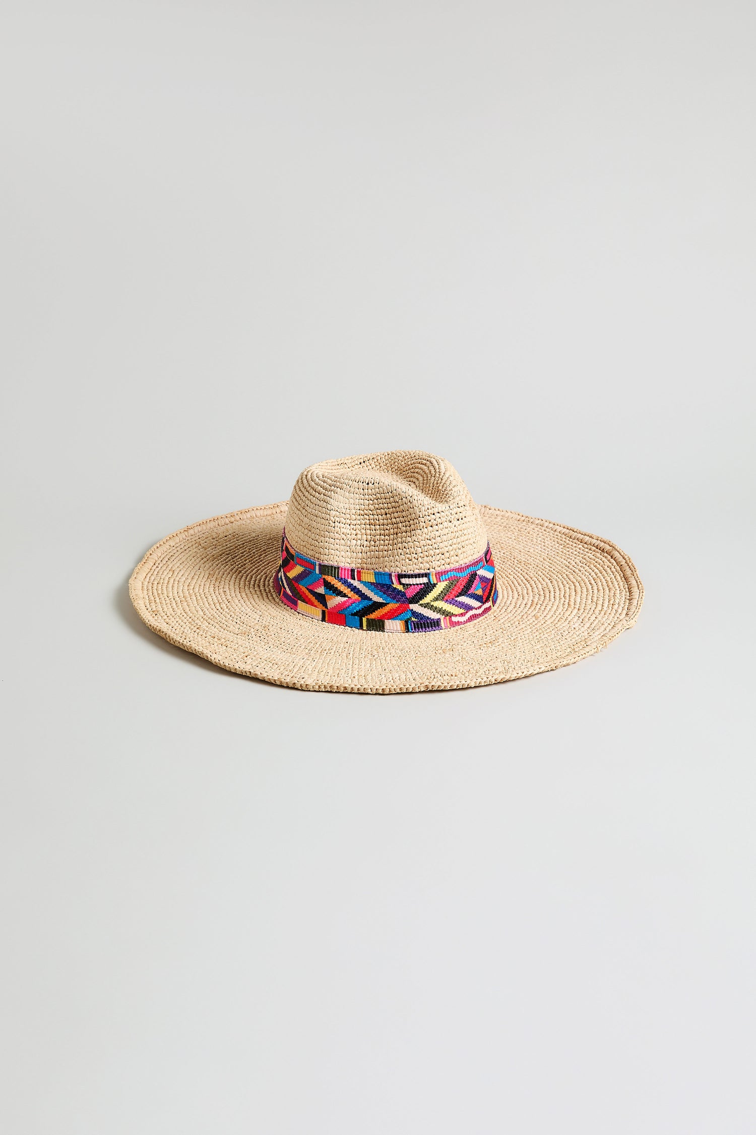 Handwoven Raffia Western Hat, model TON1160B, featuring a wide brim and a colorful geometric-patterned band, shown on a plain light background.