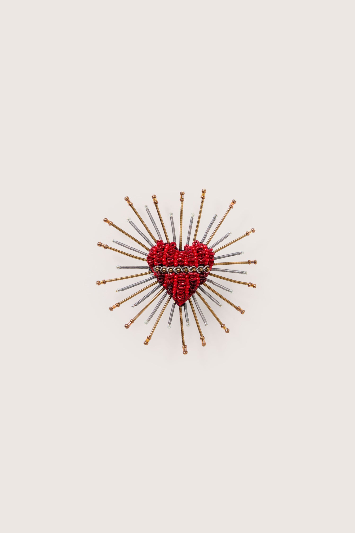 A Sacred Heart Embroidered Brooch with needles in it.