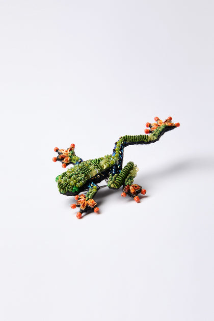 A vibrant Hand Beaded Tree Frog Brooch with an intricate design by Trovelore rests on a plain white background.