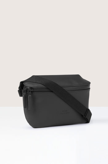 The Jona Crossbody Bag in black, crafted from vegan tech material and featuring a zipper closure with an adjustable strap, is set against a plain white background.