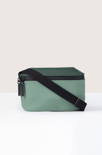 A water-repellent green Jona Crossbody Bag crafted from vegan tech material features a black adjustable strap and two black zipper pulls, all set against a neutral background.