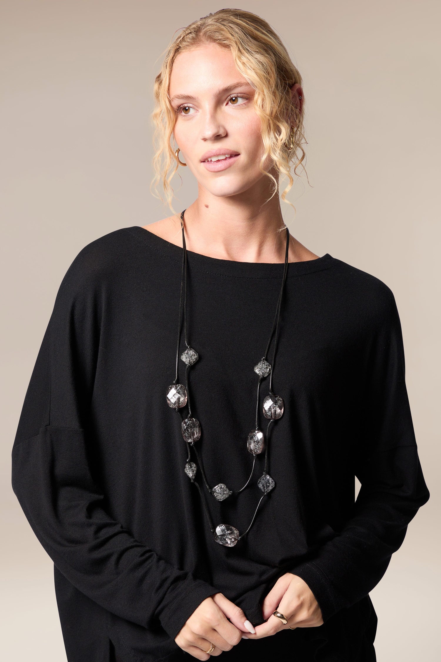 A woman wearing a black sweater and a Silver Leaf Pebble Necklace.