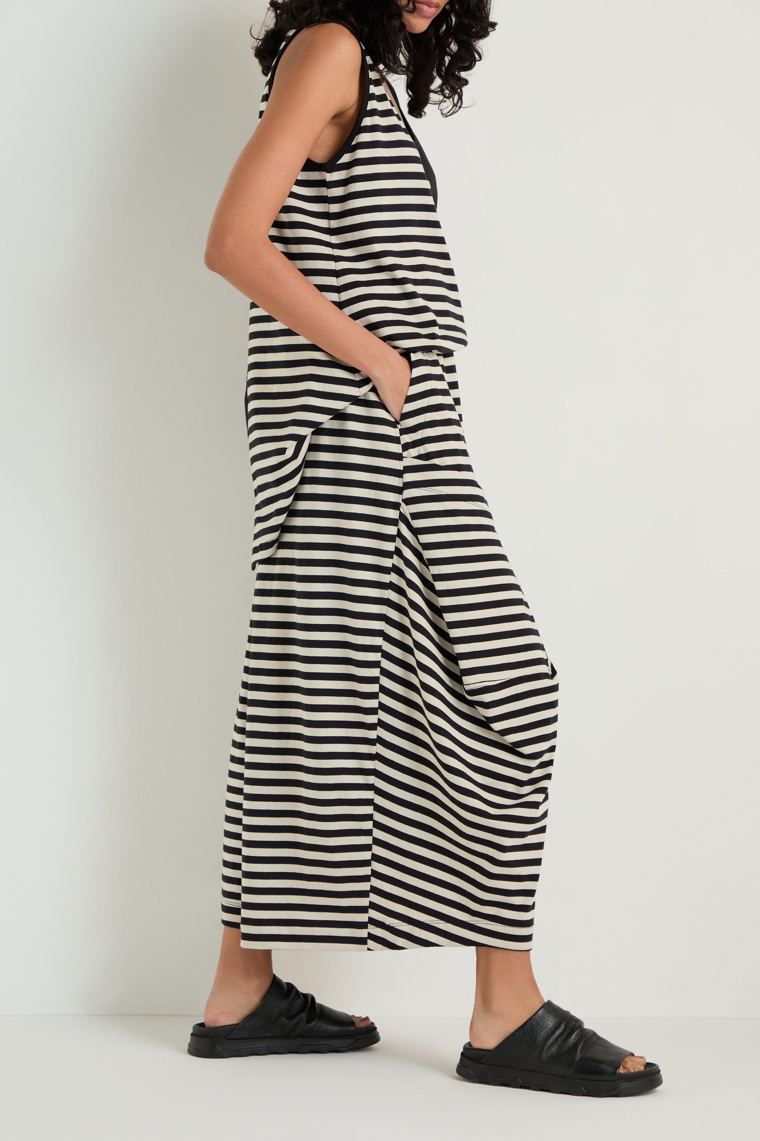 A person wears Stripe Balloon Trousers with a matching black and white striped sleeveless top and black sandals, posing against a plain white background.