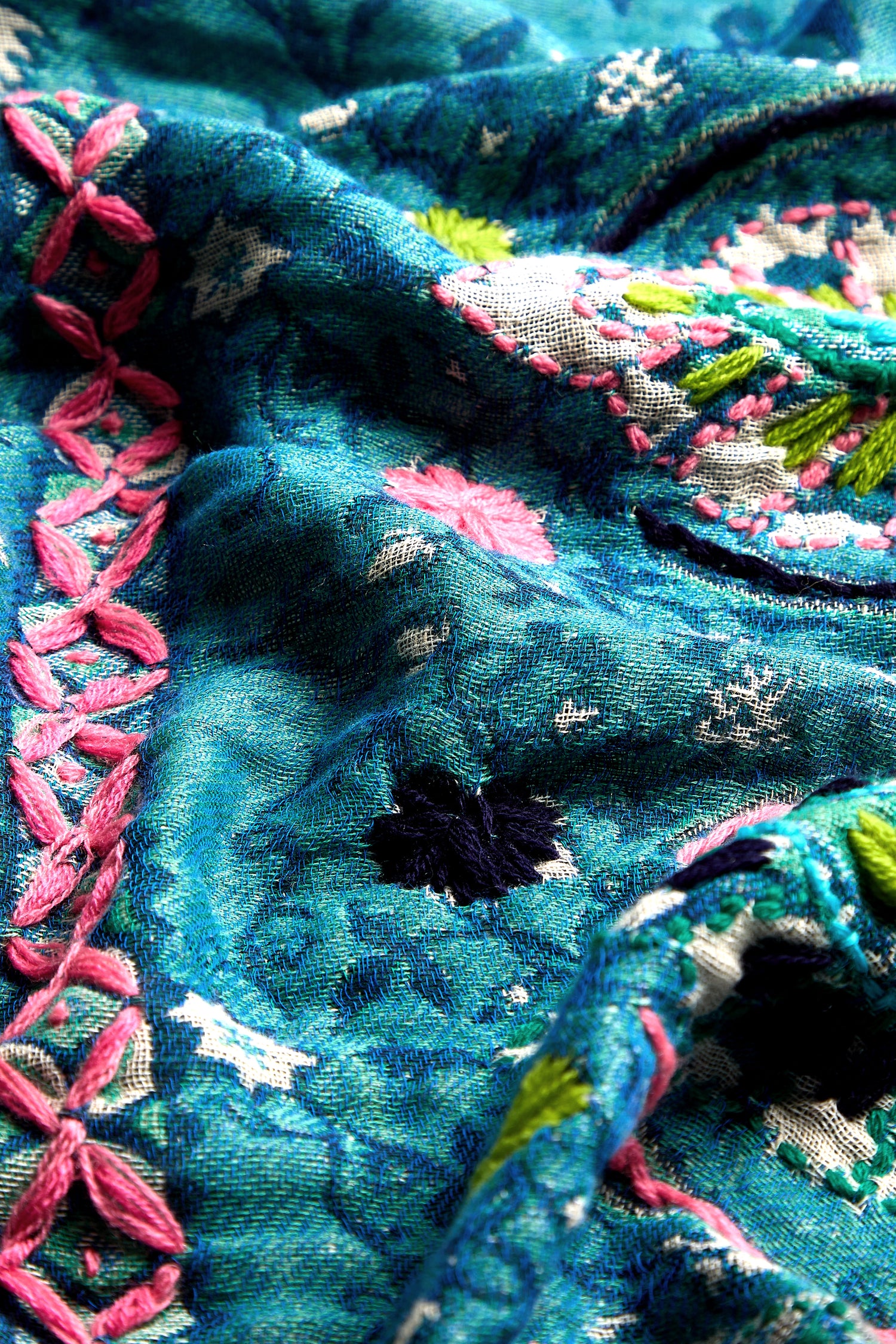 Close-up of a Cerulean Hand Embroidered Jacket, showcasing colorful and intricate floral embroidery with pink, white, green, and black thread—reminiscent of a delicately hand-embroidered kimono-style jacket.