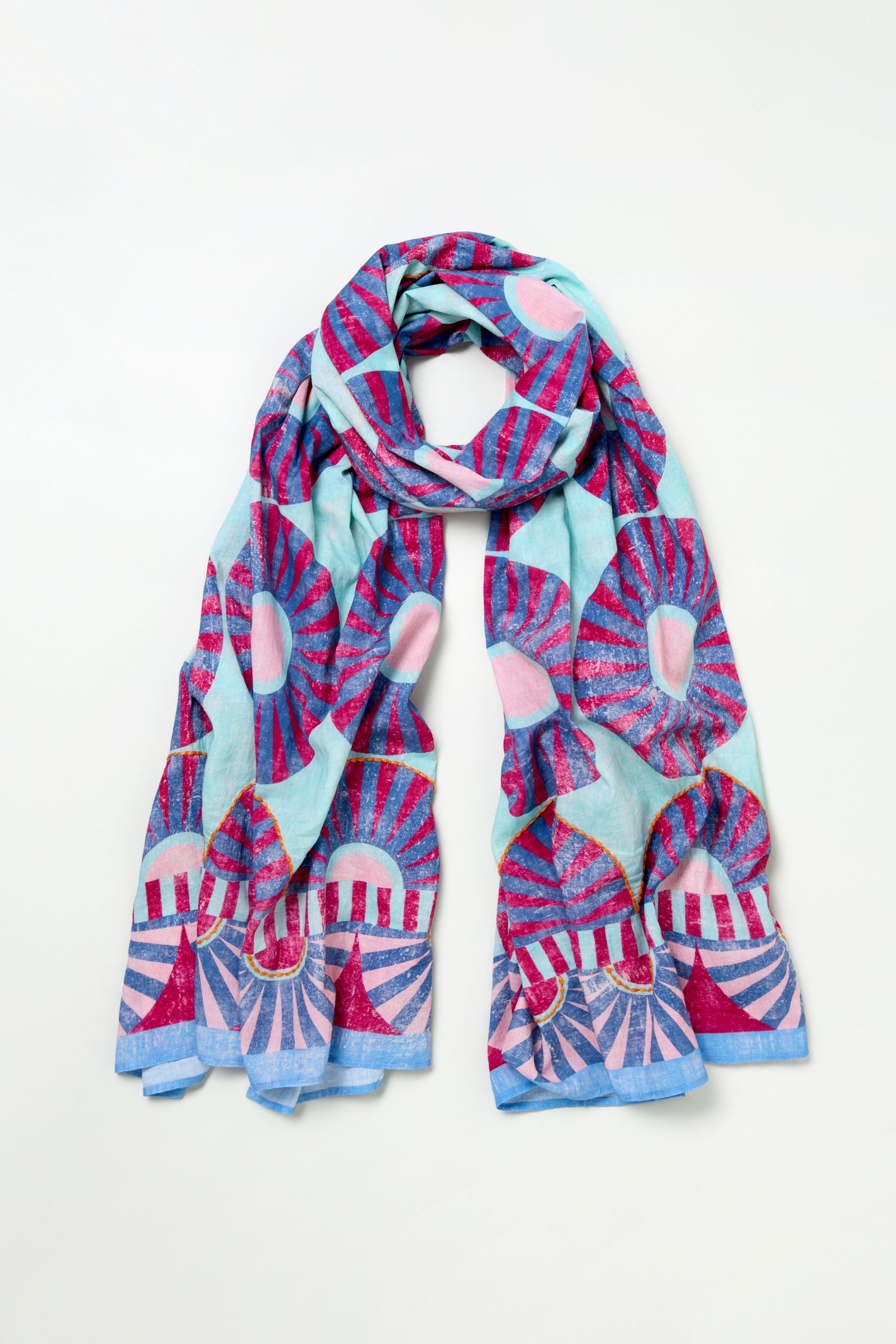 The Embroidered Parasols Cotton Scarf features a blue background with pink, red, and light blue geometric sunburst patterns inspired by parasols, displayed flat on a white surface.