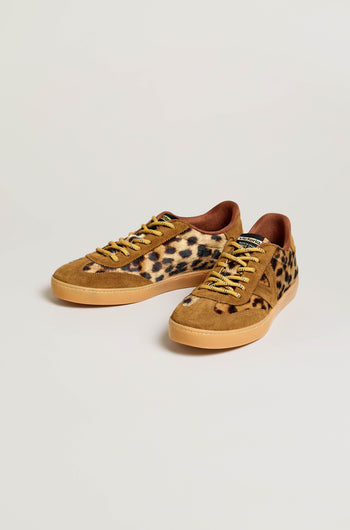 A pair of Berlin Animal Print Trainers featuring tan soles, brown suede accents, yellow laces, and a leopard print pattern on the sides, crafted in Spain and shown against a plain light background.