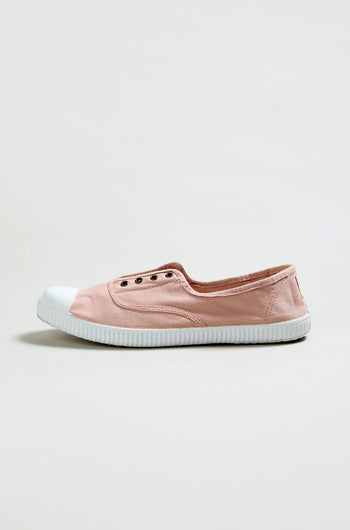 The Inglesa Light Pink Pumps, an online exclusive slip-on sneaker, features a white rubber toe cap and sole. Shown from the side against a plain background.