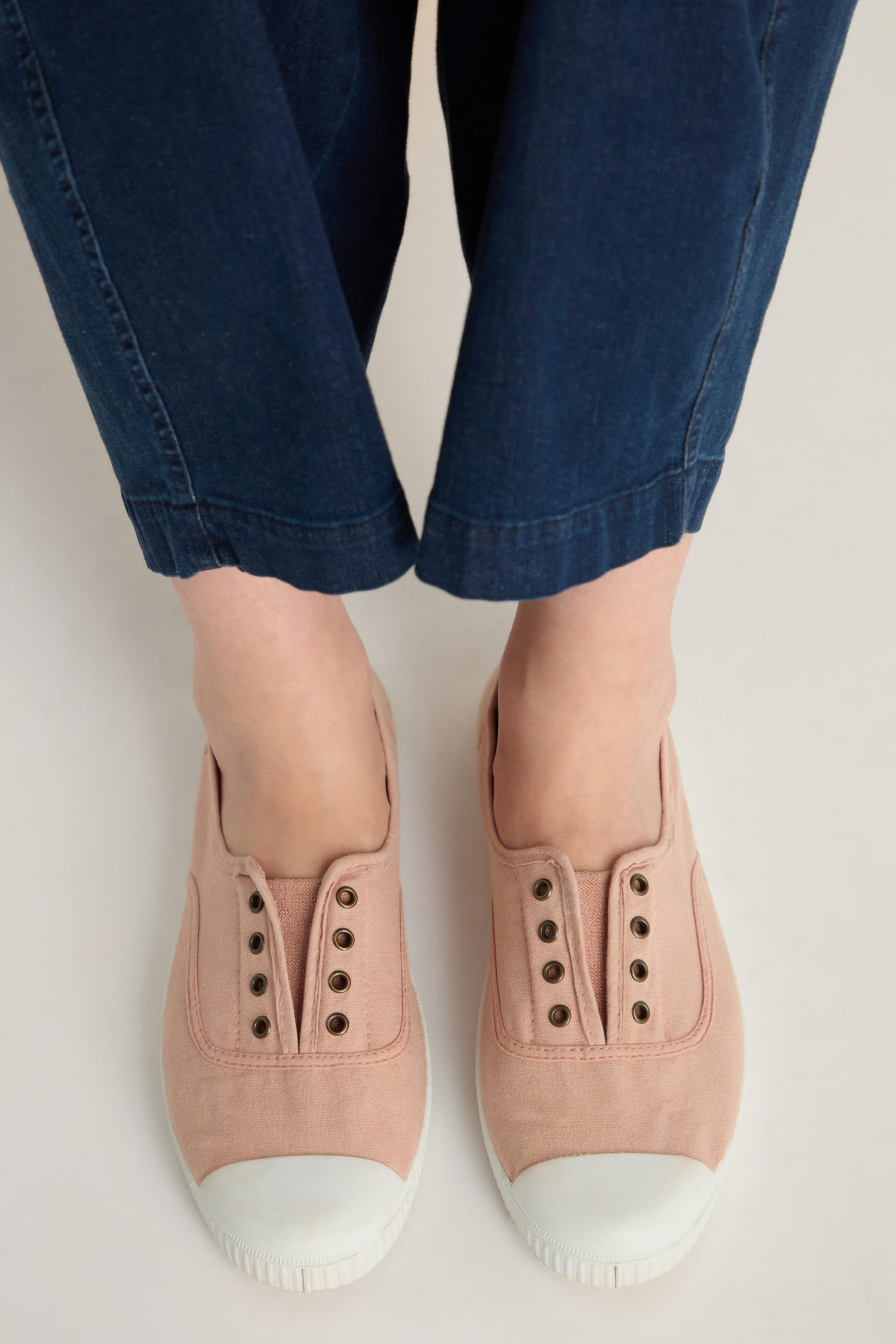 Person wearing blue pants and Inglesa Light Pink Pumps made in Spain, viewed from above against a light background.