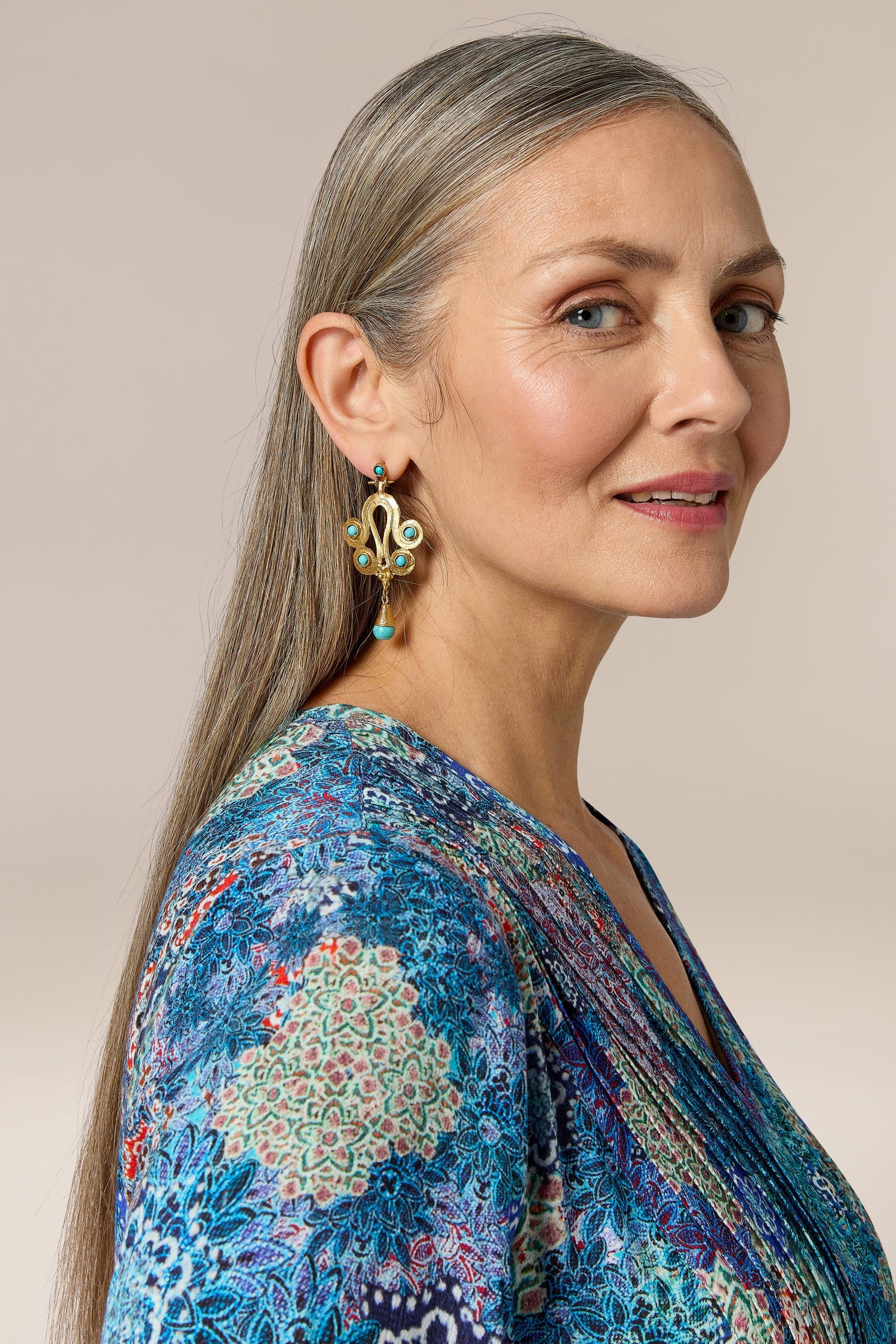 A woman wearing Handcrafted Ottoman Earrings and a blue floral print top.