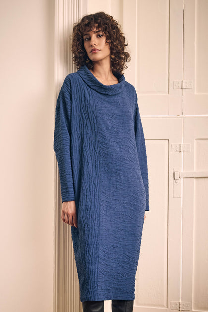 A model wears a cobalt Wave Textured Crinkle Dress, a long-sleeved midi design with a cowl neckline and a crinkled finish.