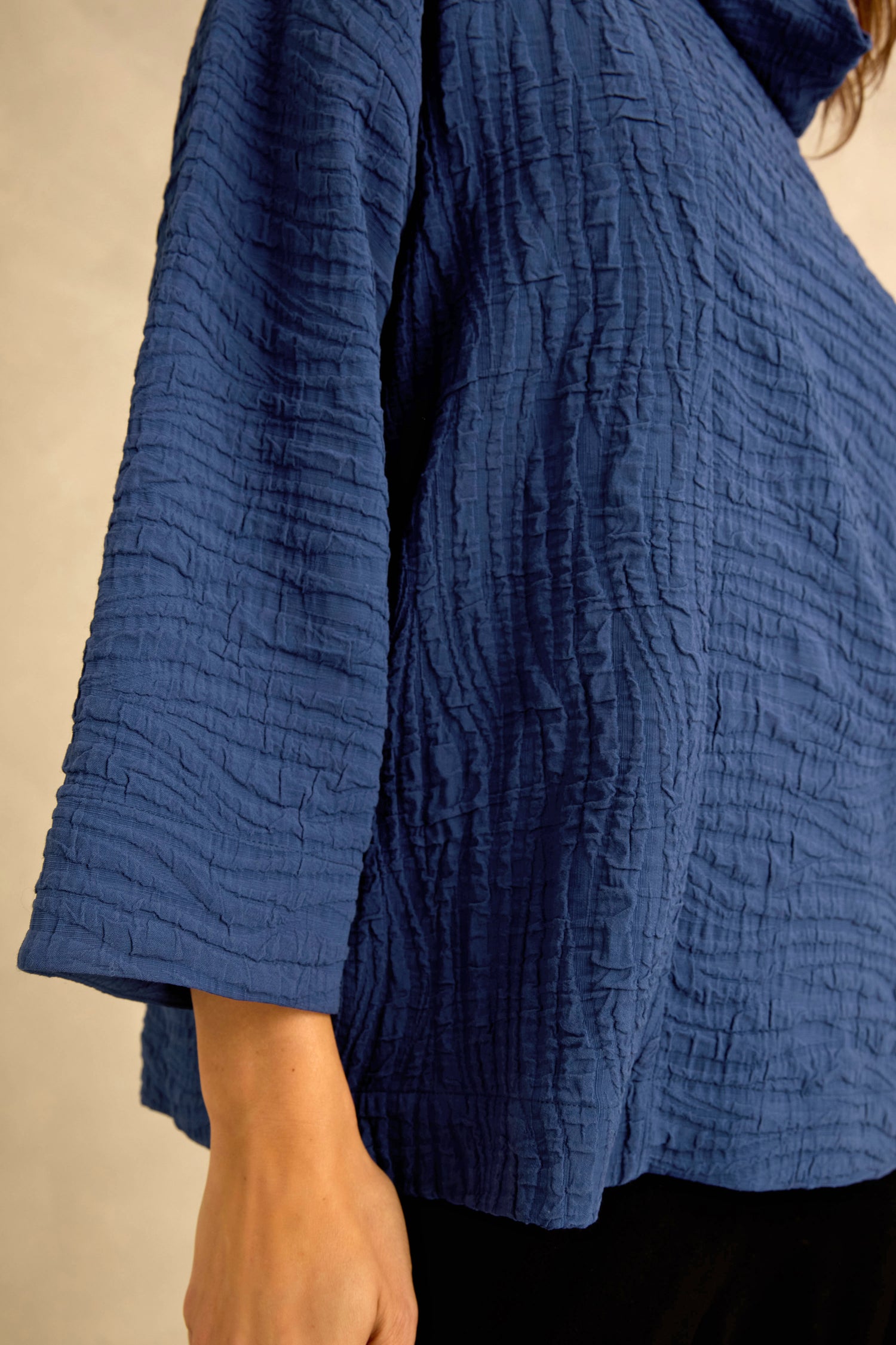 A person is wearing the Cobalt Wave Textured Crinkle Cowl Neck Top, which features a wave texture, relaxed boxy shape, and wide sleeves; only the torso and part of one arm are visible.