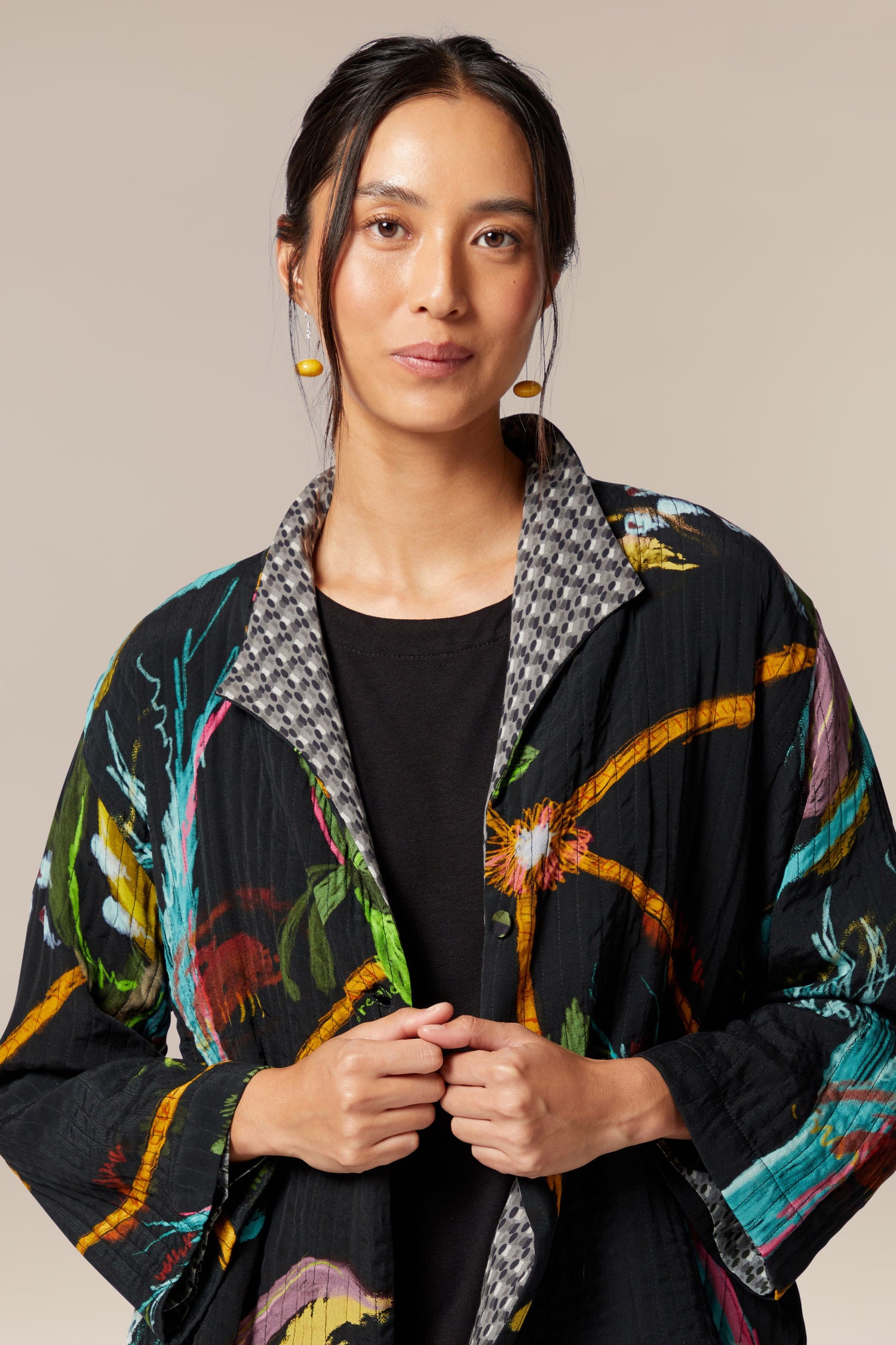 A woman wearing an ethereal Painterly Floral Jacket with a large-scale floral print.