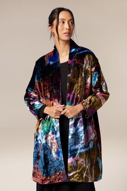 A woman wearing a Floral Velvet Jacket with a classic shawl collar.