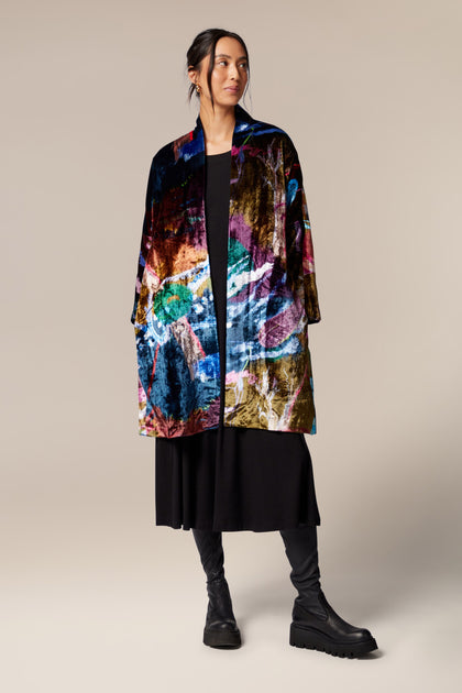 A woman wearing a Floral Velvet Jacket with a classic shawl collar.