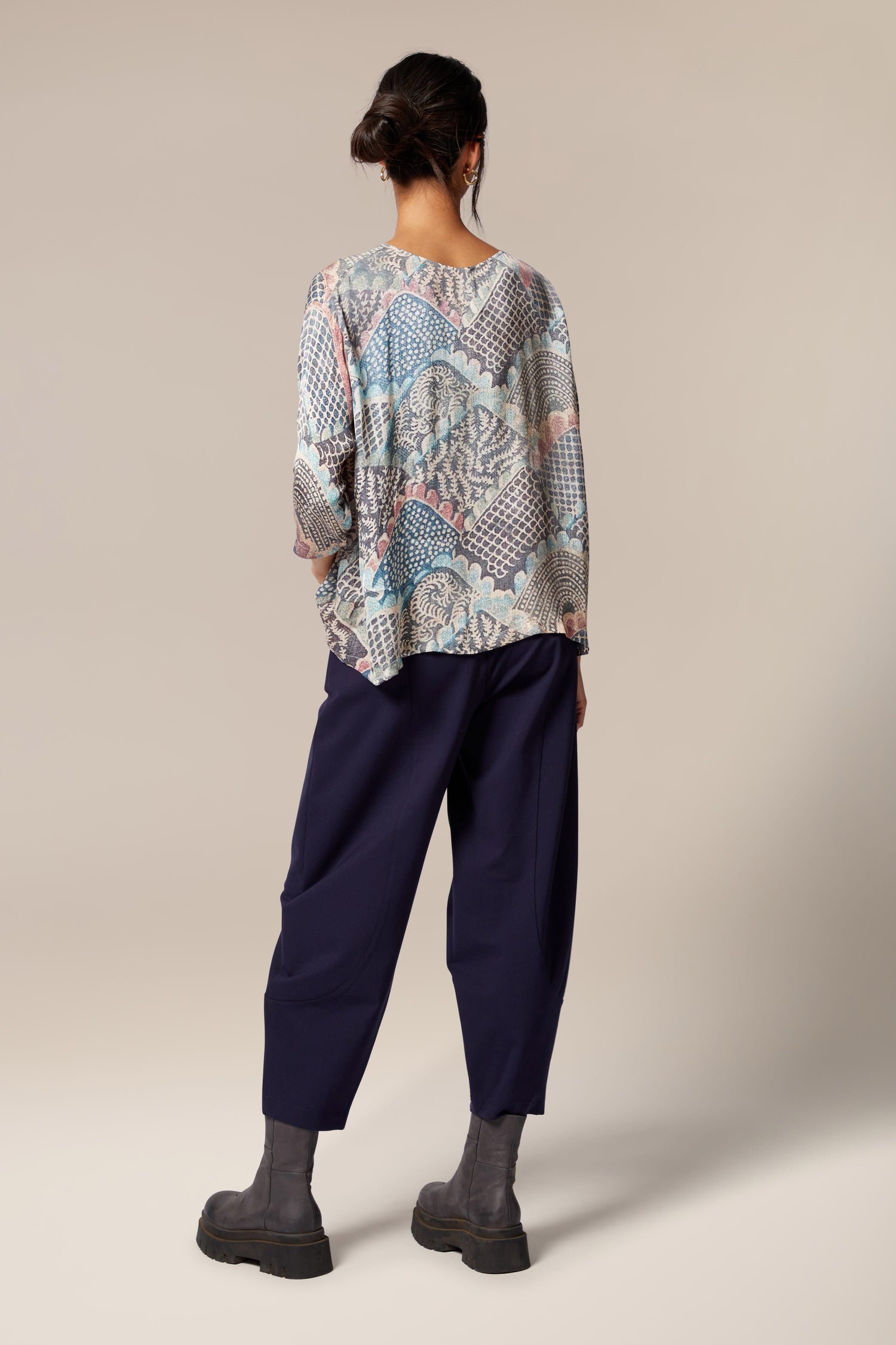 The back view of a woman wearing a boxy silhouette long sleeved Mosaic Print Top.