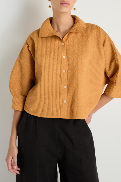 A person wears the Pleated Sleeve Brown Shirt paired with black pants, standing against a plain light background.