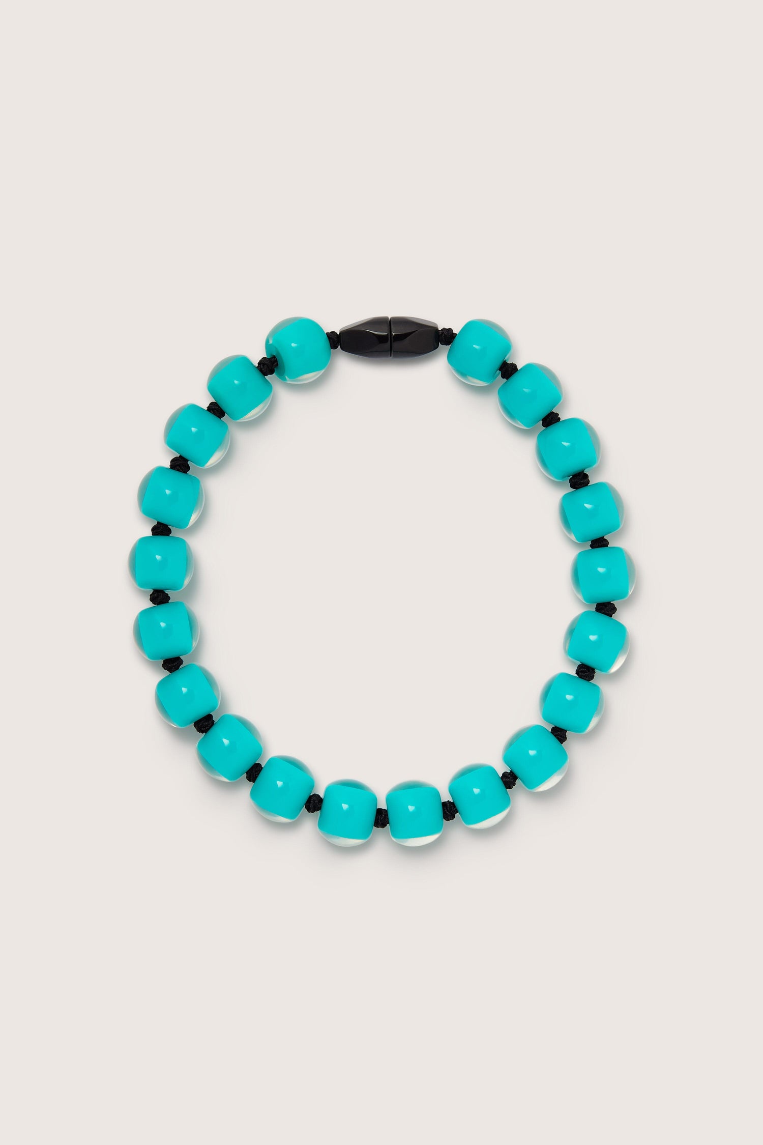 An Aqua Colourful Bead Necklace with vibrant blue resin beads and a black magnetic clasp arranged in a circular shape.