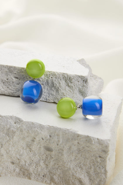 Two pairs of Colourful Beads Double Sphere Earrings are displayed on textured stone blocks against a white fabric background.