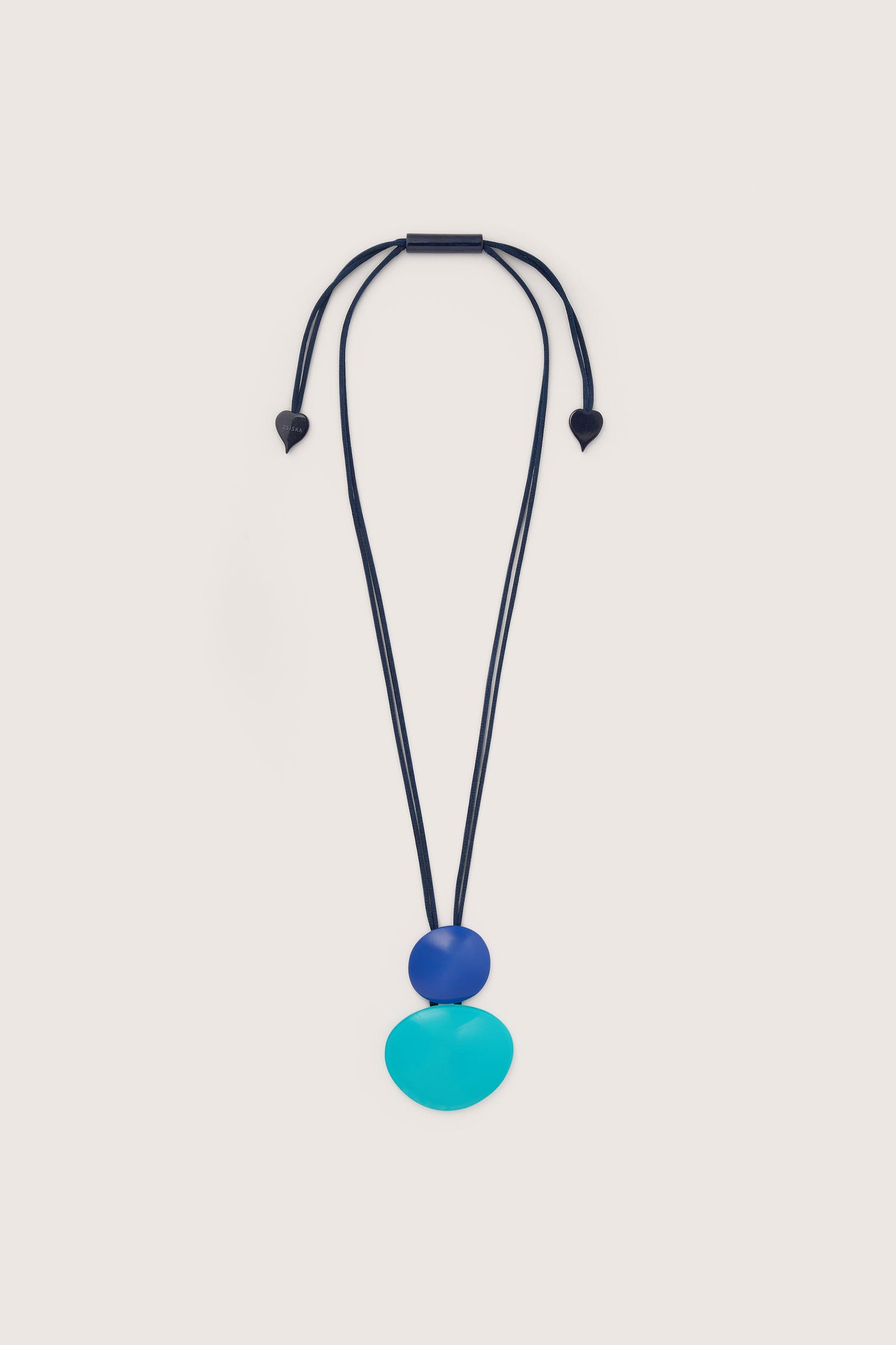 A statement piece necklace with a blue Crystal Cube Pendant on a black cord.