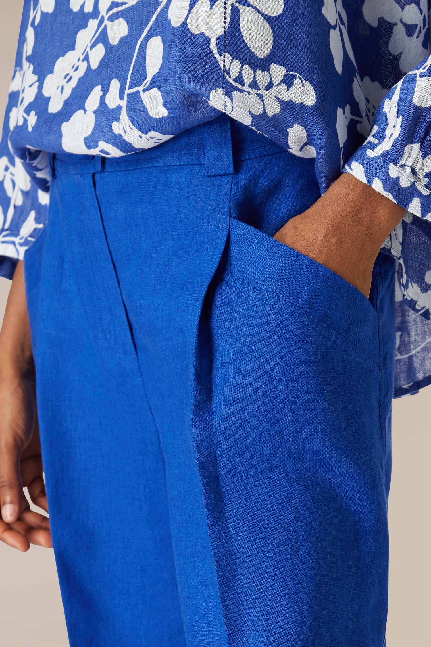 A person wearing Bradley Linen Shorts with a pocket.