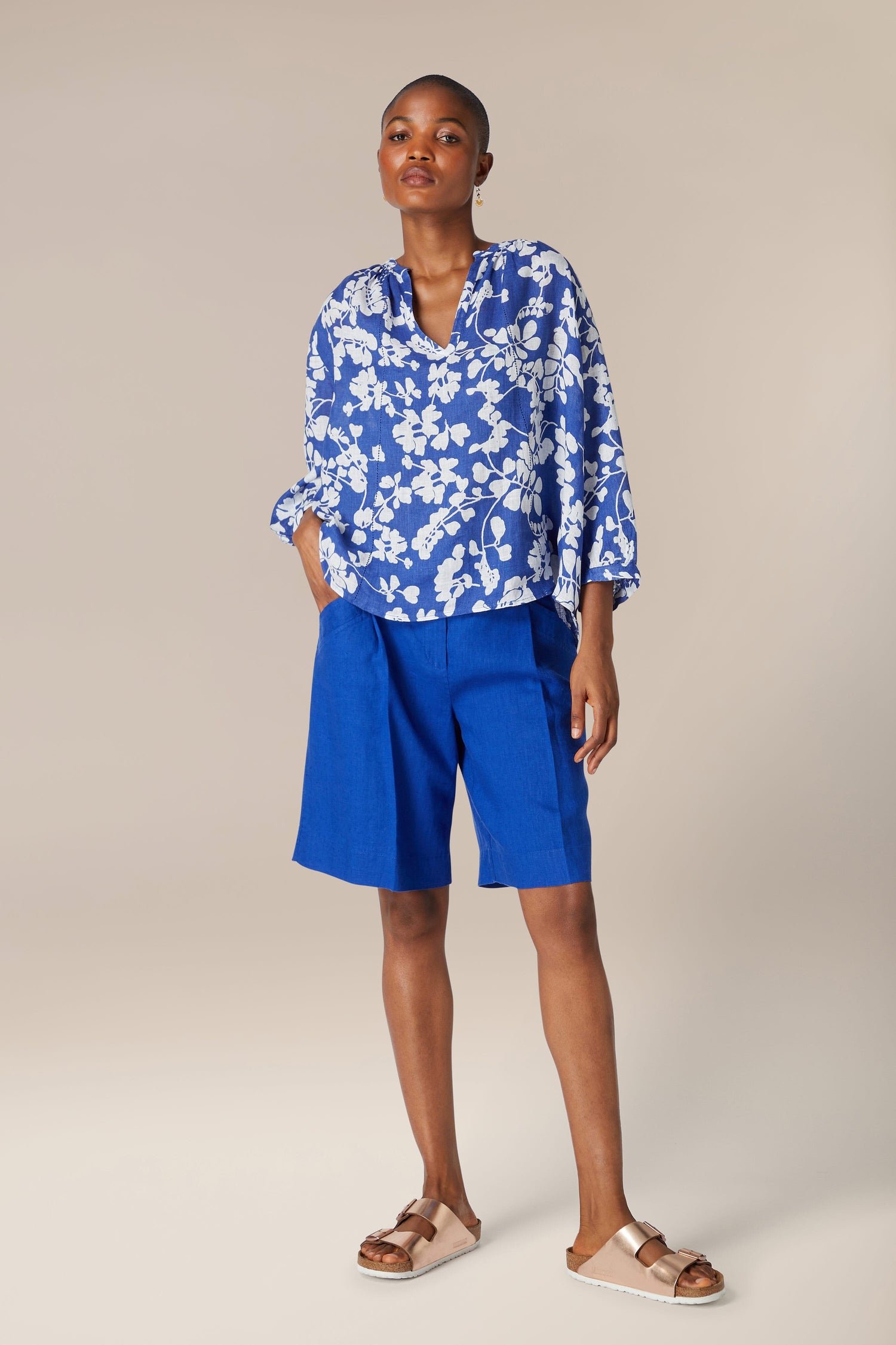 A woman in a blue and white shirt and Bradley Linen Shorts.