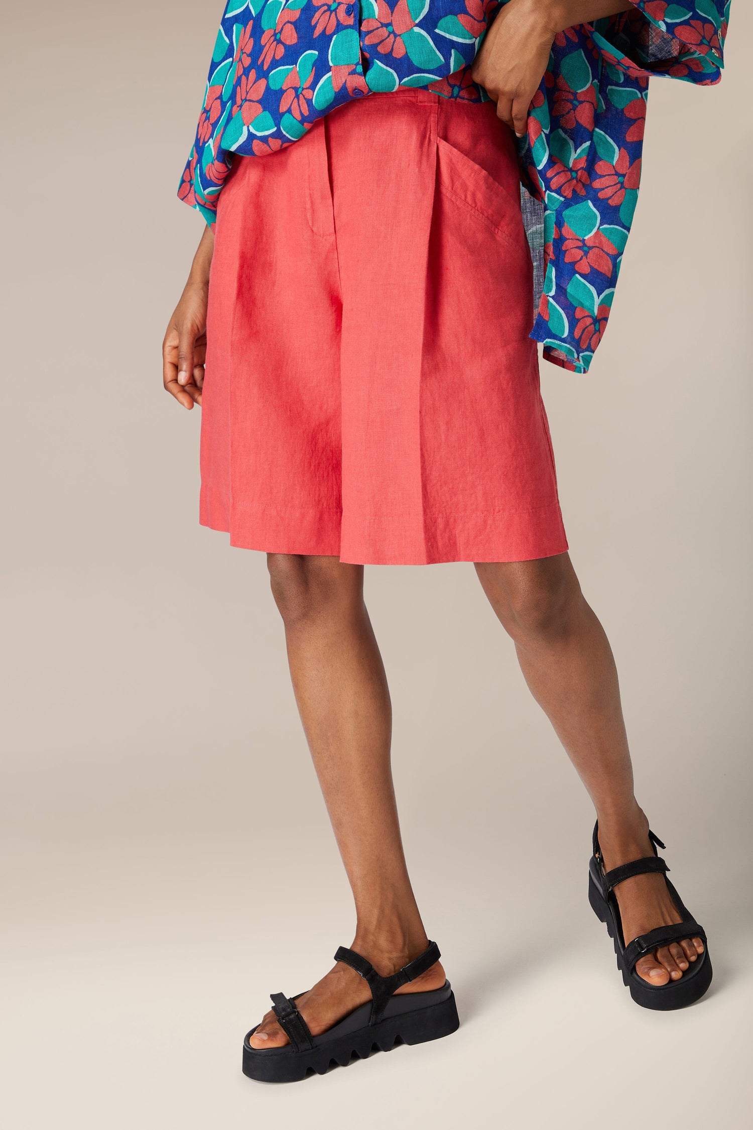 A woman wearing Bradley Linen Shorts and sandals.