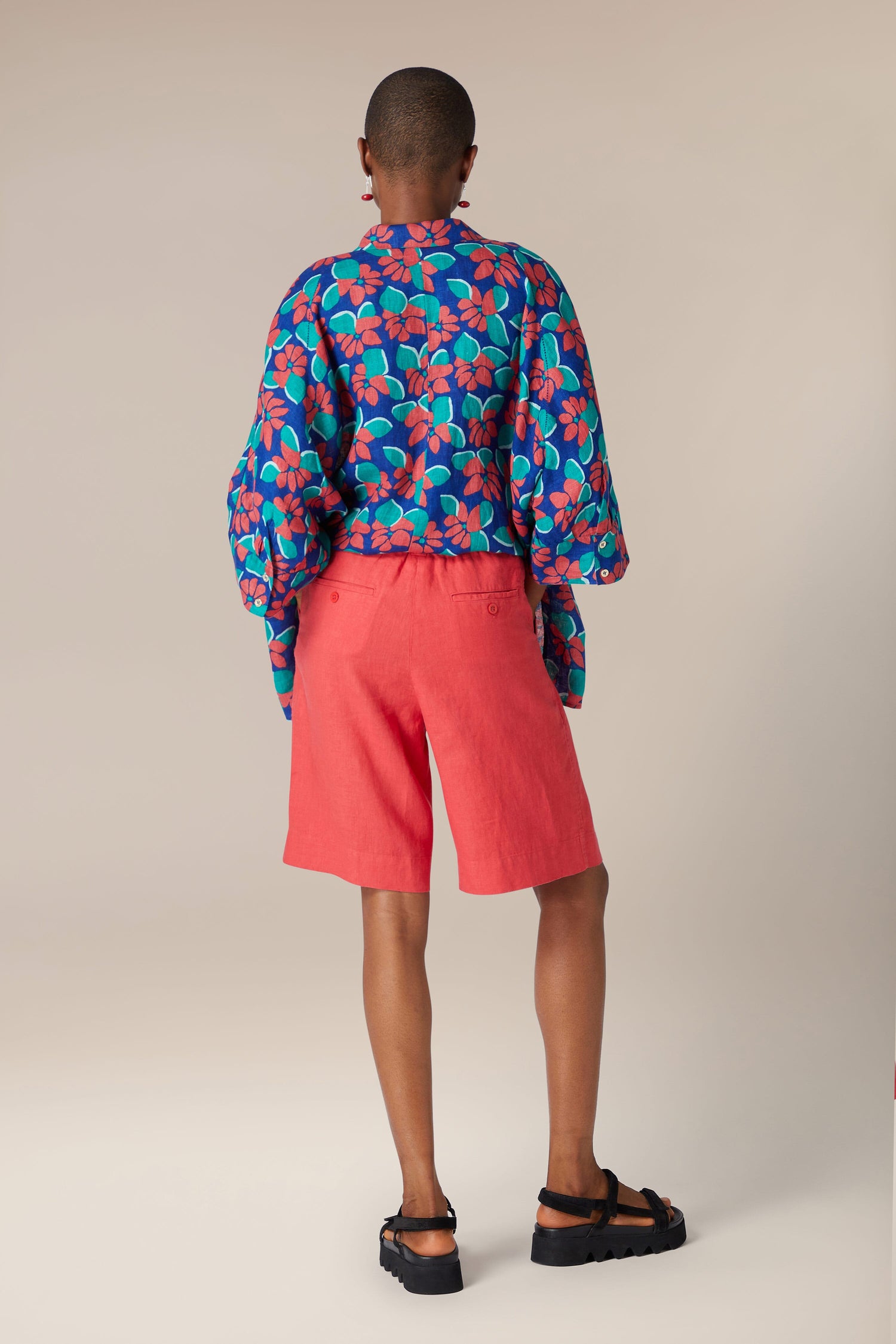 A person wearing a blue and red shirt and Bradley Linen Shorts.