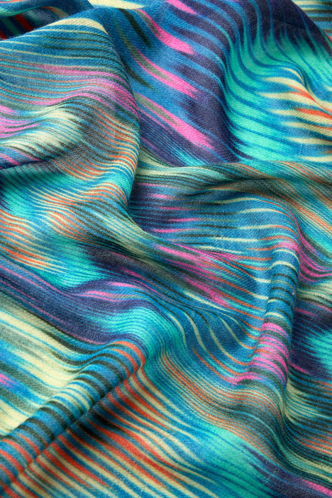 Close-up of the Autumnal Ikat Wool Scarf featuring vibrant stripes in blue, pink, yellow, and green. This stylish accessory has a soft, textured feel perfect for adding autumnal hues to any outfit.