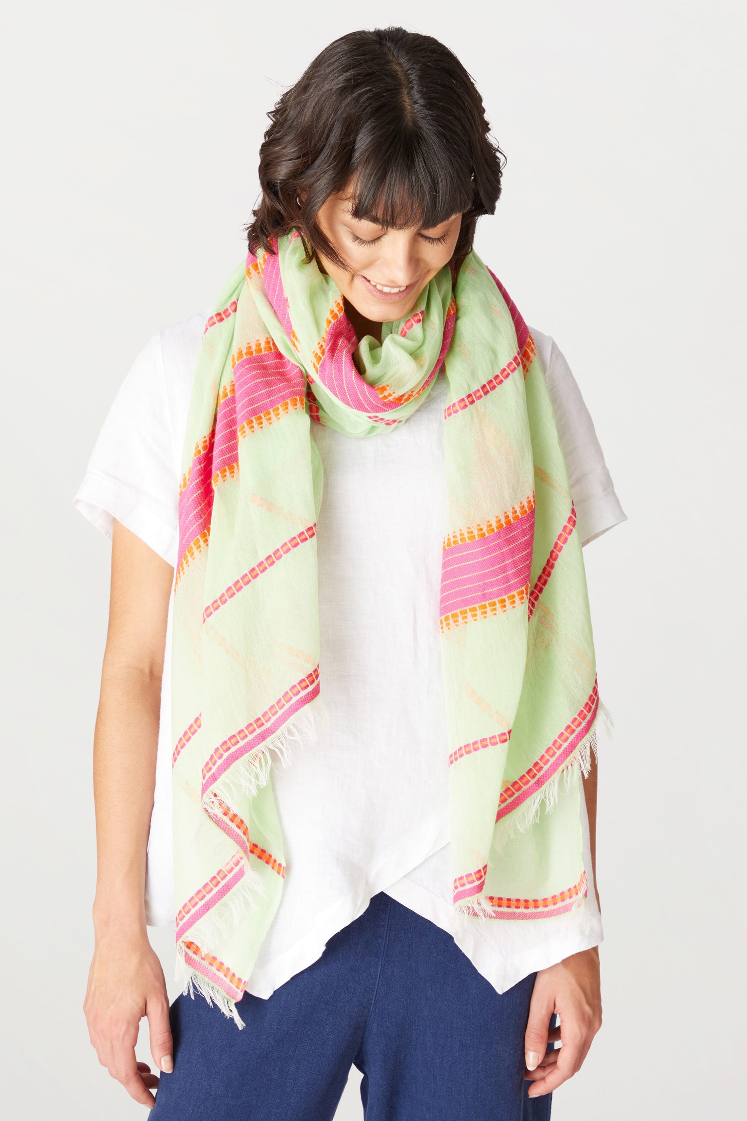 A woman in a white shirt and an Embroidered Stripe Scarf.