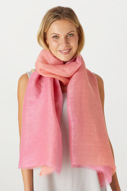 A smiling woman wearing a luxurious Ombre Scarf, with a plain white background.