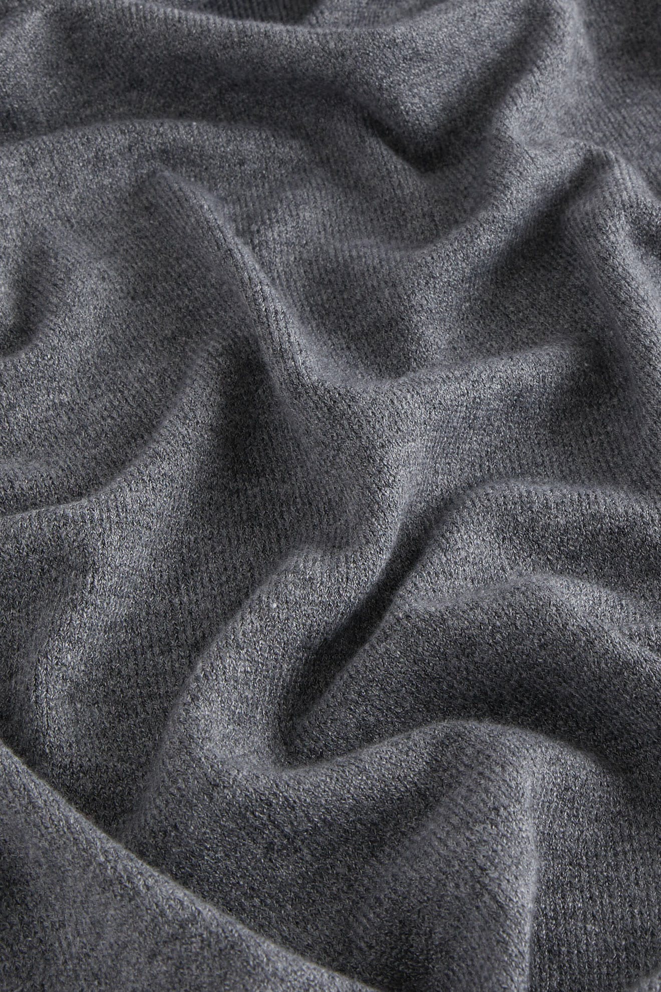 Close-up of dark gray, soft, textured fabric with folds—ideal for a luxury Knit Scarf or cozy winter accessory.