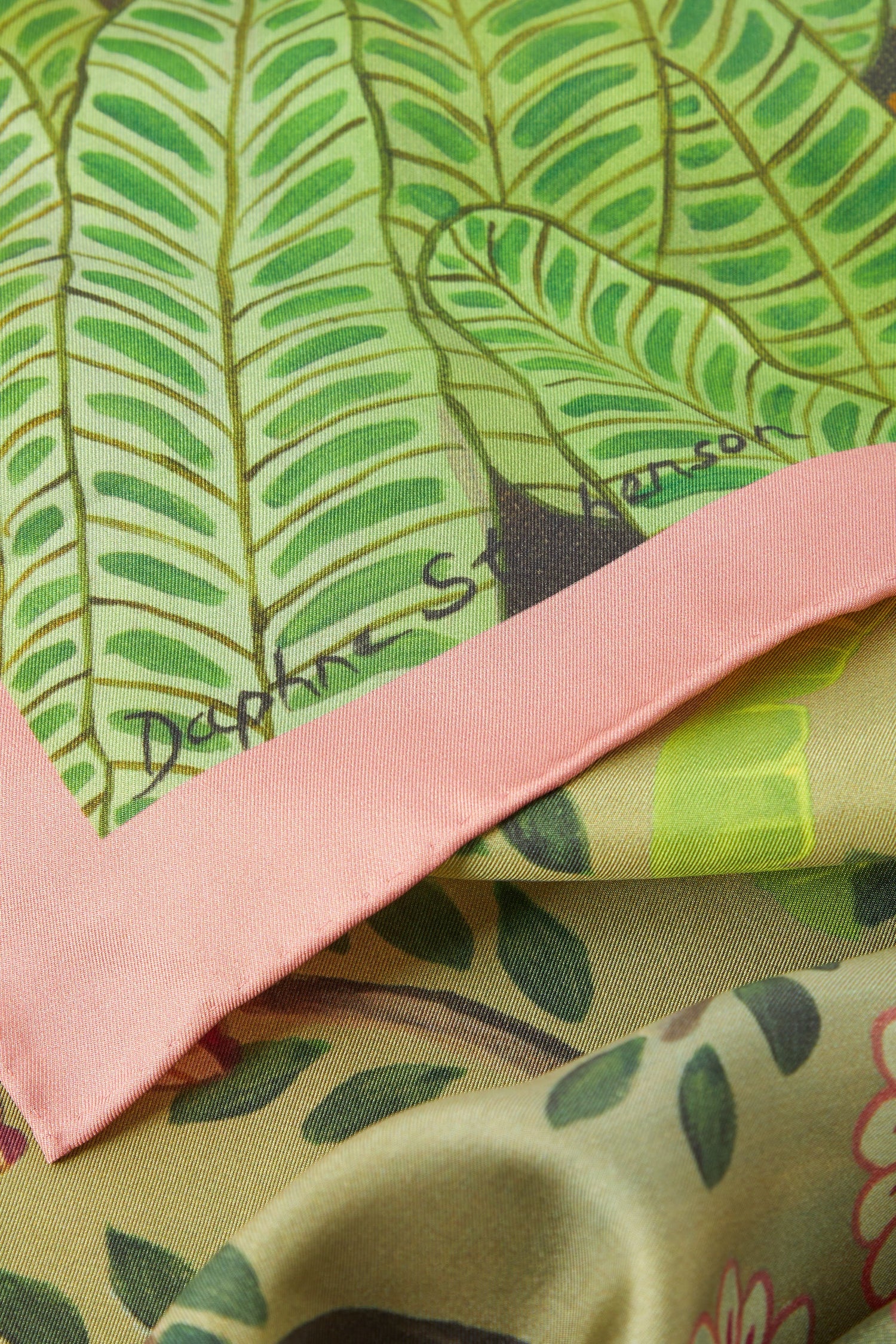 An artist-designed Are You Coming With Me Silk Scarf with green and pink prints of leaves on it.