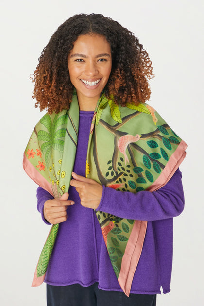 An artist wearing a purple sweater and "Are You Coming With Me" silk scarf with unique prints.